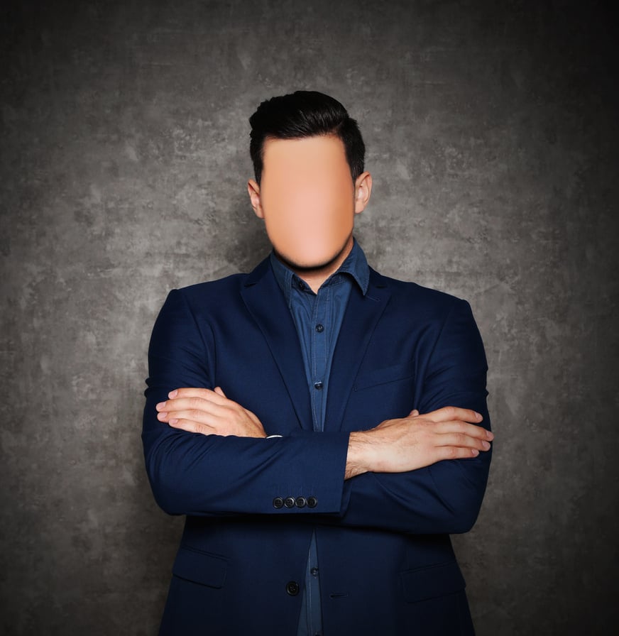 Anonymous. Faceless Man in Suit near Grey Wall